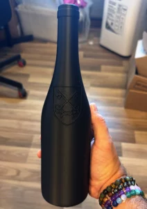 Bouteille noire imprimée en 3D avec blason en relief