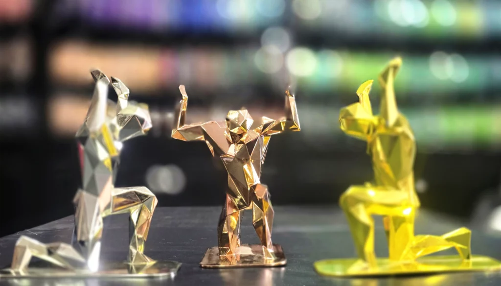 Trois figurines Atlas imprimées en 3D avec finitions différentes